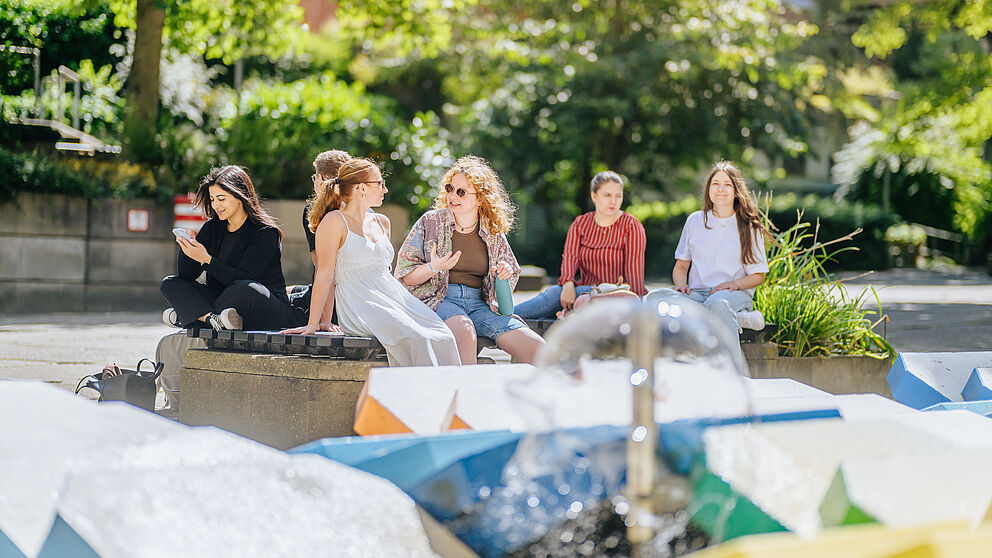 Studierende am Brunnen im Innenhof. 