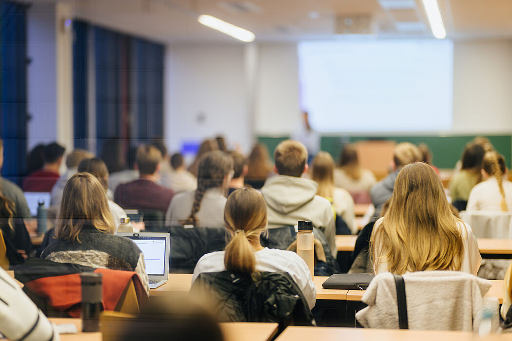 Junge Menschen sitzen in einem Seminarraum und schauen nach vorne